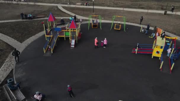 Játszótér a parkban, ahol a felnőttek sétálhatnak a gyerekeikkel. légi felvétel — Stock videók