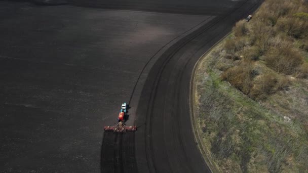 Beeldmateriaal van een trekker die het land in het veld ploegt — Stockvideo