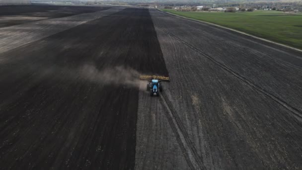 A large, heavy-duty blue tractor plows the ground. preparing the land for this. — Stock Video
