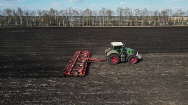 Sidovy av en traktor som plöjer marken för sådd av säd. Flygfotografering — Stockvideo