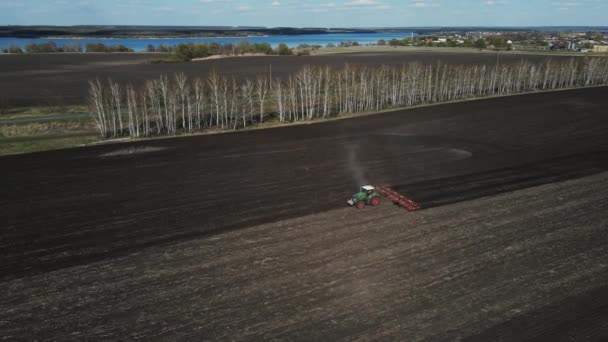 Grüner Traktor pflügt ein Feld für die Aussaat von Land. Luftaufnahmen — Stockvideo