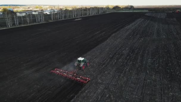 Ein großer grüner Harvester pflügt das Land für die Aussaat. Luftaufnahmen — Stockvideo