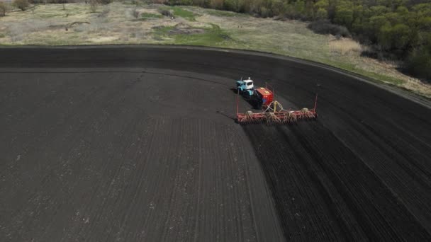 Traktor jede přes pole a orá půdu. letecké snímání — Stock video