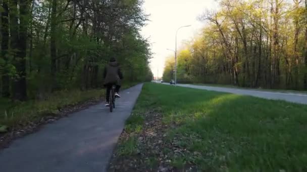 Cara monta uma bicicleta em um caminho de bicicleta — Vídeo de Stock