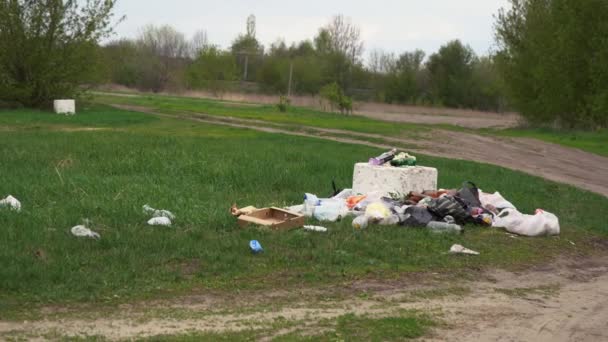 Un montón de basura yaciendo en la hierba. — Vídeo de stock