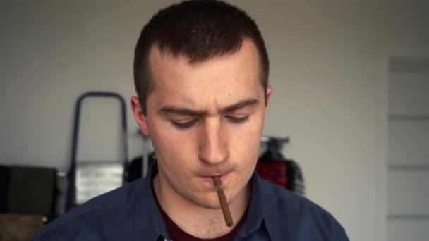 Ένας άντρας ανάβει τσιγάρο στο δωμάτιο. — Αρχείο Βίντεο