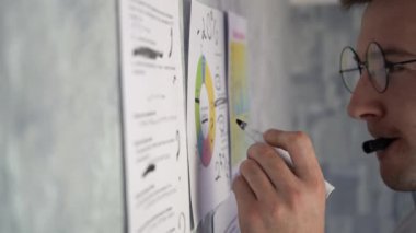 Adam duvardaki çizelgelere not alıyor..