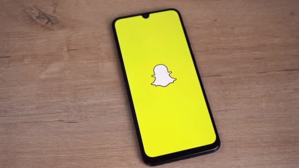Snapchat logo is displayed on the phone screen. Moscow Russia 05 May 2021 — Stock Video
