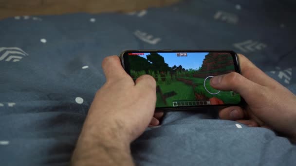 The guy plays minecraft on the phone. Moscow Russia April 14, 2021 — Vídeo de Stock