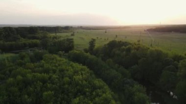 drone movement along green forest and fields. aerial shooting