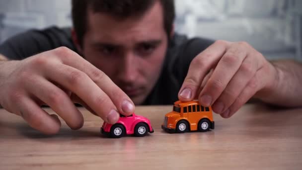 Дорослий чоловік грає в іграшкові автомобілі вдома — стокове відео