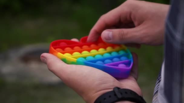 Mann spielt Pop it Spielzeug einfache Grübchen auf der Straße stehen — Stockvideo