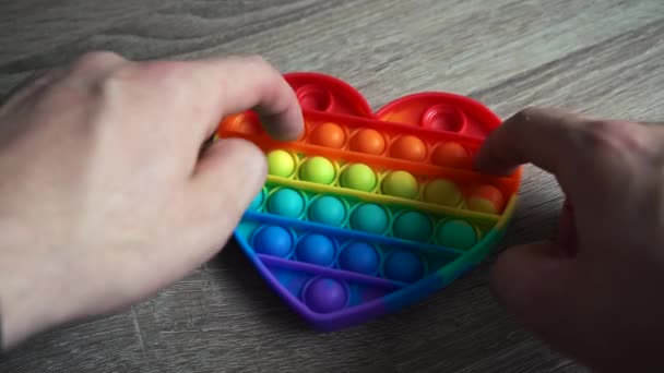 Jongen spelen speelgoed pop het eenvoudige kuiltje zitten aan de tafel — Stockvideo