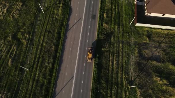 Imagens aéreas de uma escavadora em movimento na estrada — Vídeo de Stock