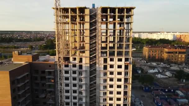 Будівництво багатоповерхового будинку на заході сонця. повітряна стрільба — стокове відео