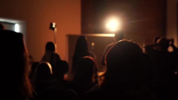 Silhouettes sombres de personnes assises dans une pièce sombre — Video