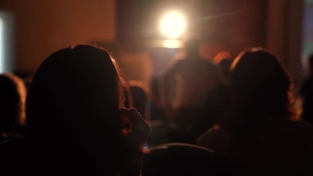 Silhouettes de personnes assises dans le hall sur la performance — Video