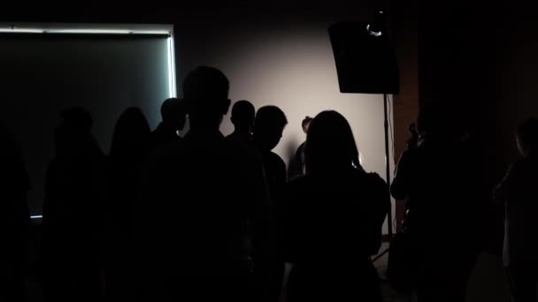 Silhouettes de photographes dans une classe de maître dans une pièce sombre — Video