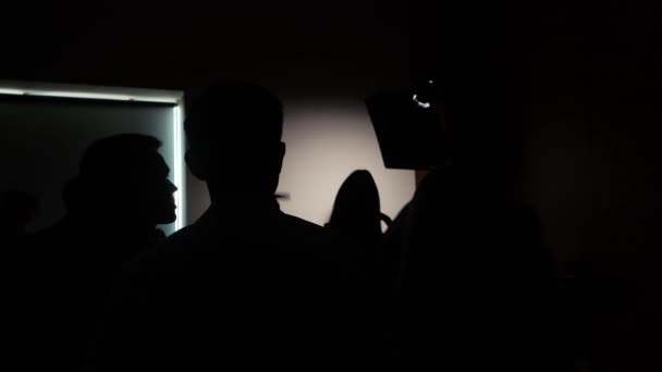 Silhouetten van fotografen in een masterclass in een donkere kamer — Stockvideo