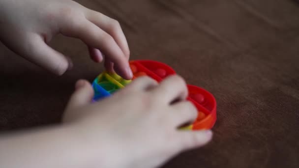 Niño jugando con juguete pop es simple hoyuelo primer plano corazón en forma de sofá — Vídeos de Stock