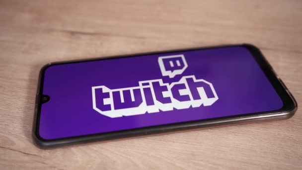 Phone with the twitch logo lies on a wooden table. Moscow Russia June 4, 2021 — Stock Video