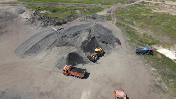 Un cargador carga piedra triturada en un camión volquete. disparos aéreos — Vídeos de Stock