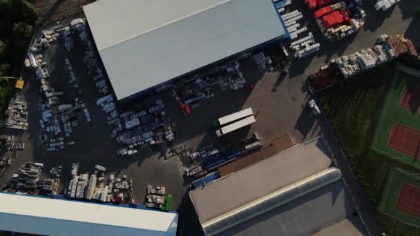 Drone gira alrededor de un almacén con materiales de construcción. disparos aéreos — Vídeo de stock
