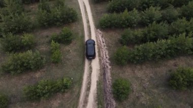 Aracın arkasında toprak bir yol boyunca insansız hava aracının hareketi