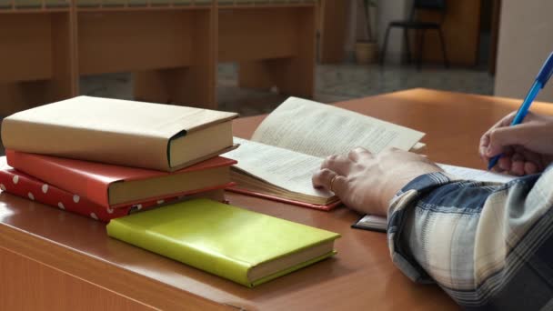 En man leder anteckningar i en anteckningsbok sitter vid bordet på kontoret — Stockvideo