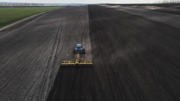 Blue tractor plows the land top view. aerial shooting — Stock Video