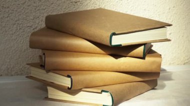 Kütüphanedeki masanın üzerinde bir yığın kitap var.