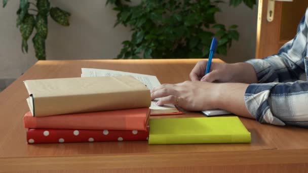 Ein Mann macht sich Notizen, während er an einem Schreibtisch in seinem Büro sitzt — Stockvideo