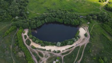 Küçük bir gölün etrafında drone hareketleri. 4K görüntüsü.
