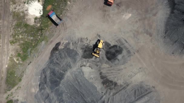 Cargador vierte piedra triturada de una pila grande en una pequeña — Vídeos de Stock