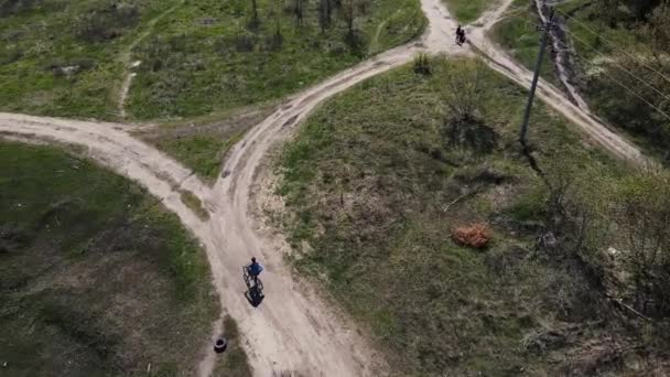 Um homem andando de bicicleta em uma estrada de terra — Vídeo de Stock