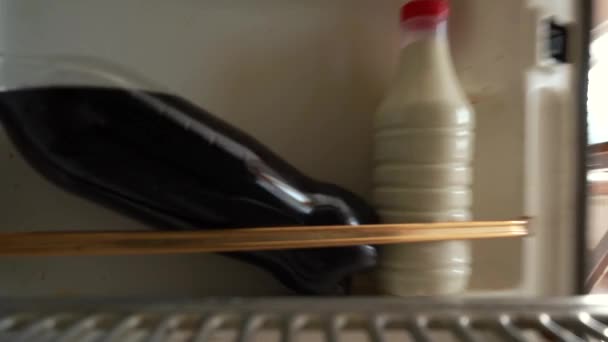 Muž vyndá mléko z ledničky. kamera uvnitř. — Stock video