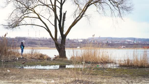 L'homme pêche dans une ville polluée sur fond d'usine — Video