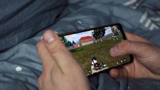 モスクワ,ロシア- 2019年12月6日:携帯電話でパブモバイルをプレイする男 — ストック動画