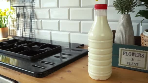 Garrafa de leite fica na mesa da cozinha — Vídeo de Stock