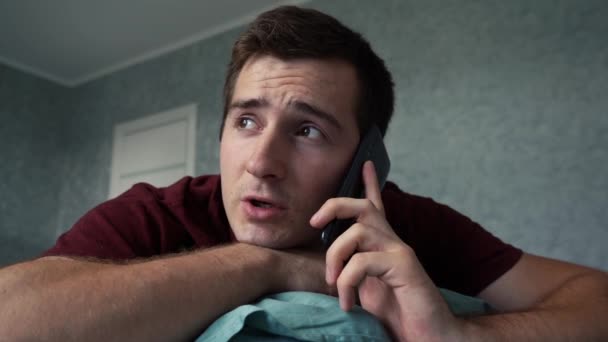 Uomo che parla al telefono sdraiato sul letto — Video Stock