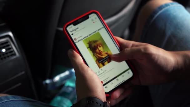 Man scrolling through the Instagram feed while sitting in the car. Moscow Russia July 29, 2021. — Stock Video