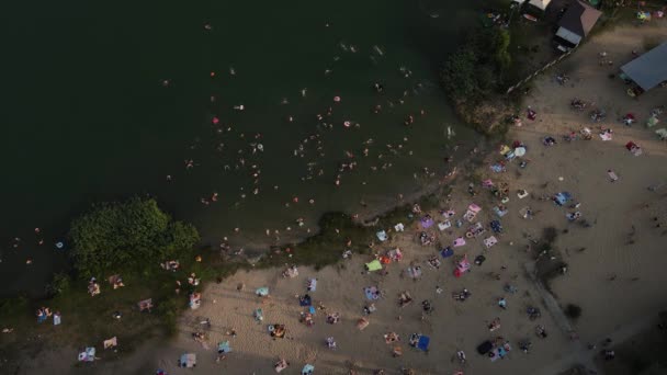 Drone filmen van een zandstrand vol met mensen bij het meer. — Stockvideo