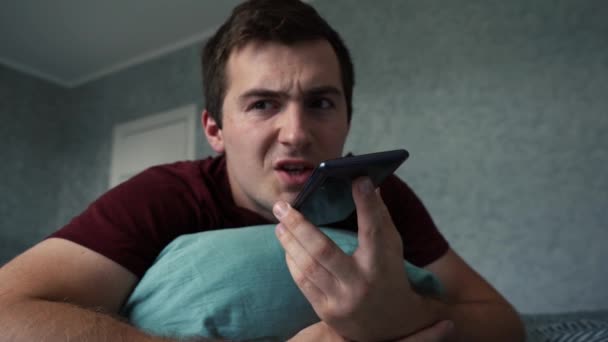 Uomo arrabbiato parlare al telefono mentre sdraiato sul letto — Video Stock