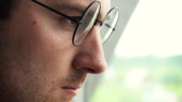Homme avec des lunettes regardant par la fenêtre — Video