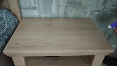 Bir adam odayı temizliyor. Bir paçavrayla tozları siler