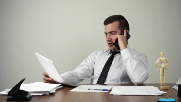 Empresário falando ao telefone enquanto sentado em sua mesa no escritório — Vídeo de Stock