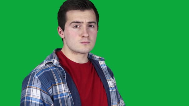 Confident guy looking at camera on green screen — Stock Video