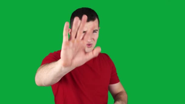 Man covering his eyes with his hands on a green screen — Stock Video