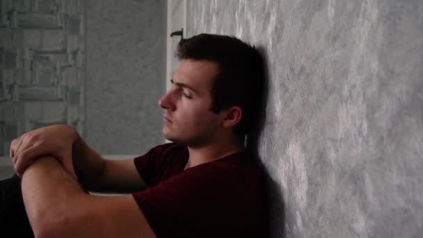 Λυπημένος άνθρωπος κάθεται στη γωνία του τοίχου — Αρχείο Βίντεο