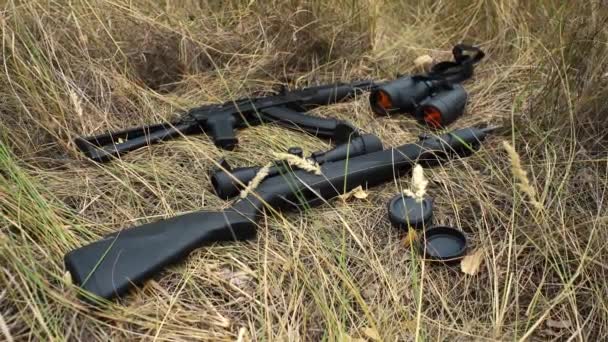 Огнестрельное оружие лежит на траве. бинокль, винтовка, пулемет — стоковое видео